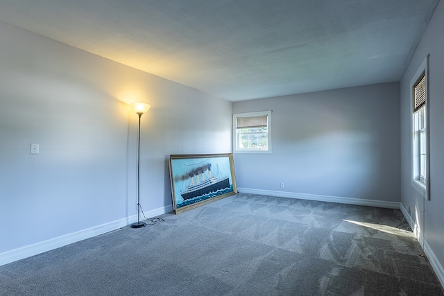 unfurnished living room with dark colored carpet