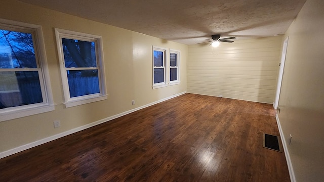 empty room featuring ceiling fan, dark hardwood / wood-style flooring, and a textured ceiling