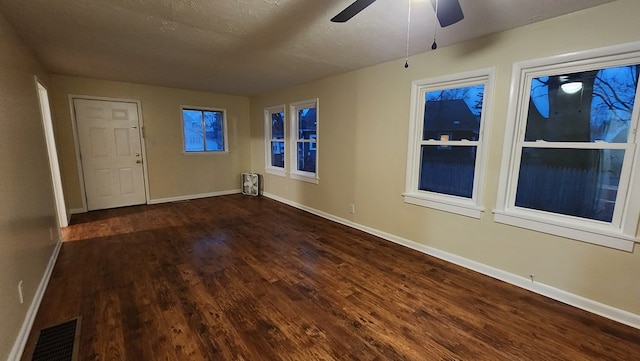 spare room with ceiling fan, dark wood-type flooring, and a textured ceiling