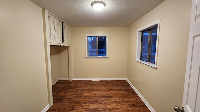 interior space with dark wood-type flooring and a textured ceiling