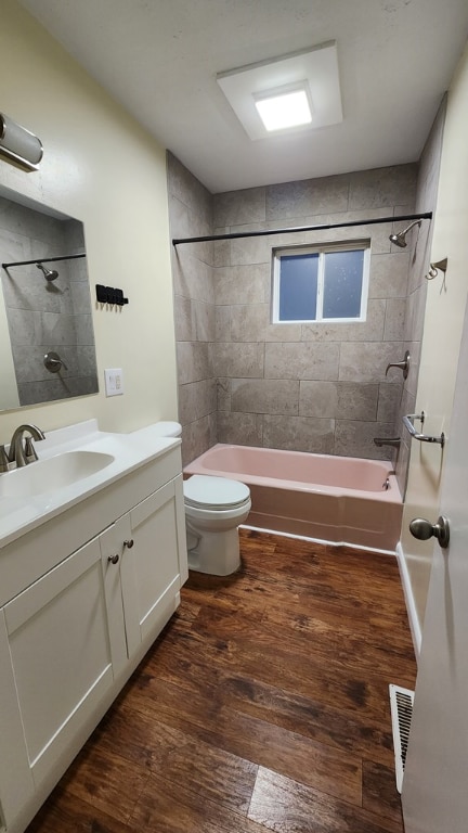 full bathroom featuring vanity, wood-type flooring, toilet, and tiled shower / bath