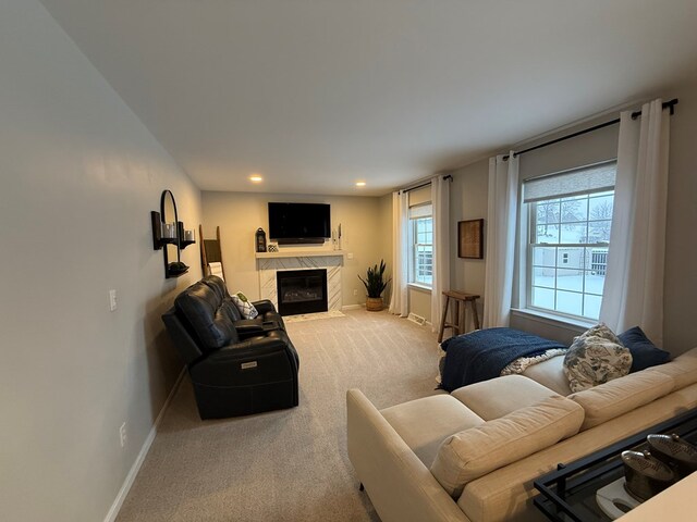 carpeted living room featuring a high end fireplace