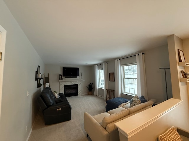 carpeted living room with a high end fireplace