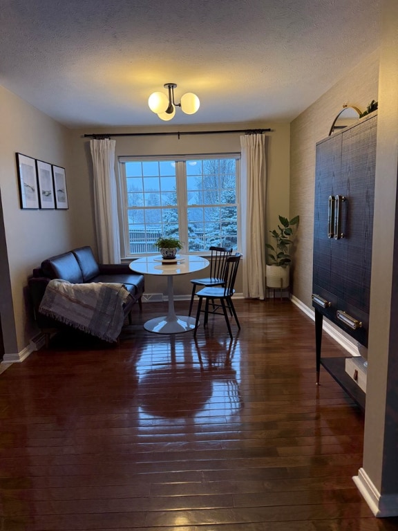 dining area featuring dark hardwood / wood-style flooring and a textured ceiling