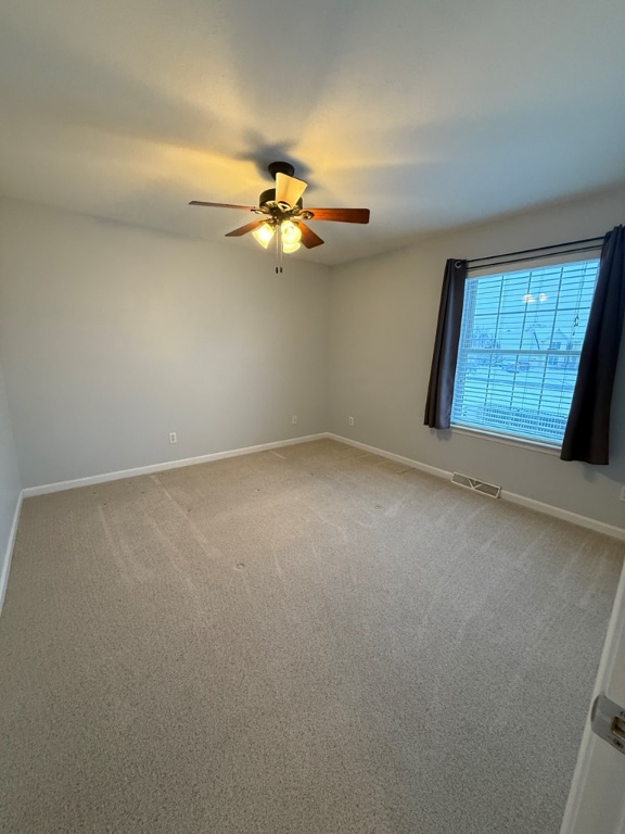 spare room with carpet floors and ceiling fan