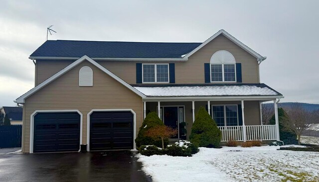 view of property featuring a garage and covered porch