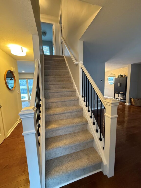 stairs featuring hardwood / wood-style floors