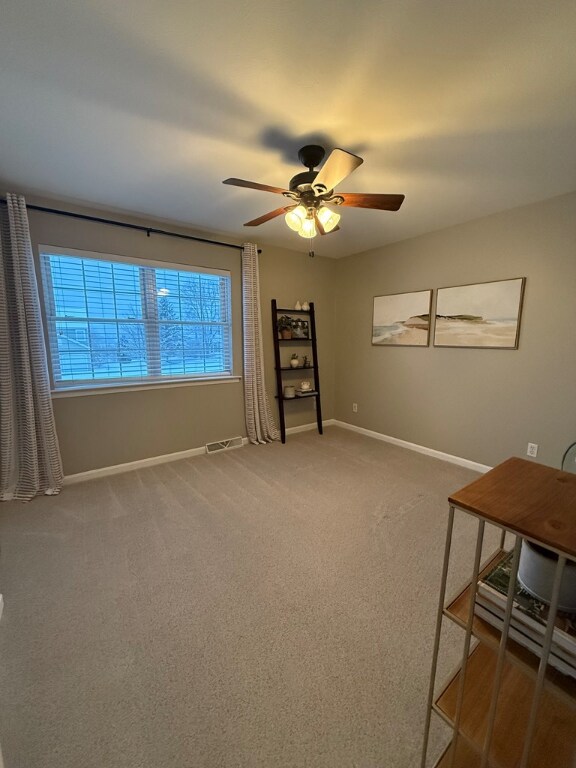 interior space with ceiling fan and carpet flooring