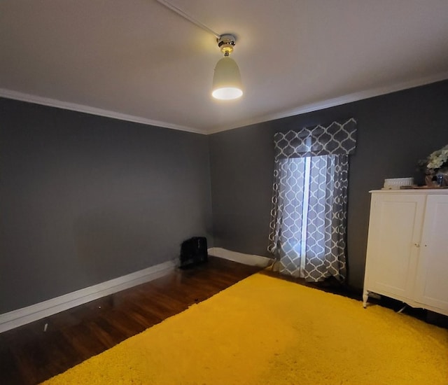 unfurnished bedroom with dark wood-type flooring and crown molding