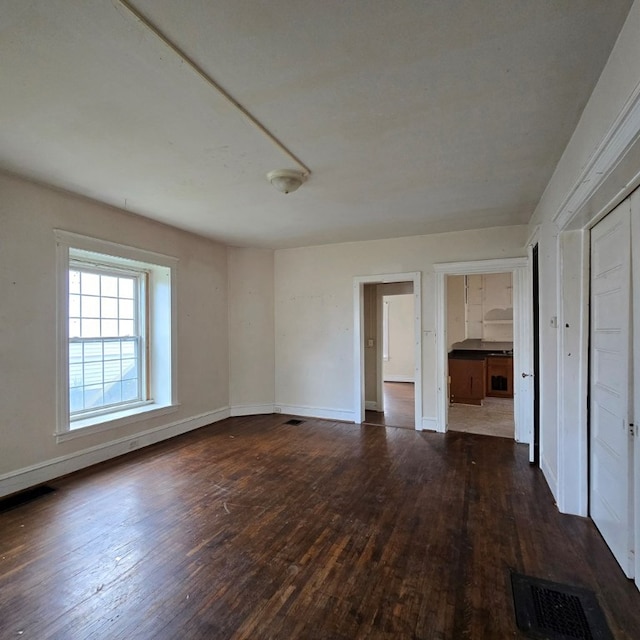 unfurnished room with dark hardwood / wood-style flooring