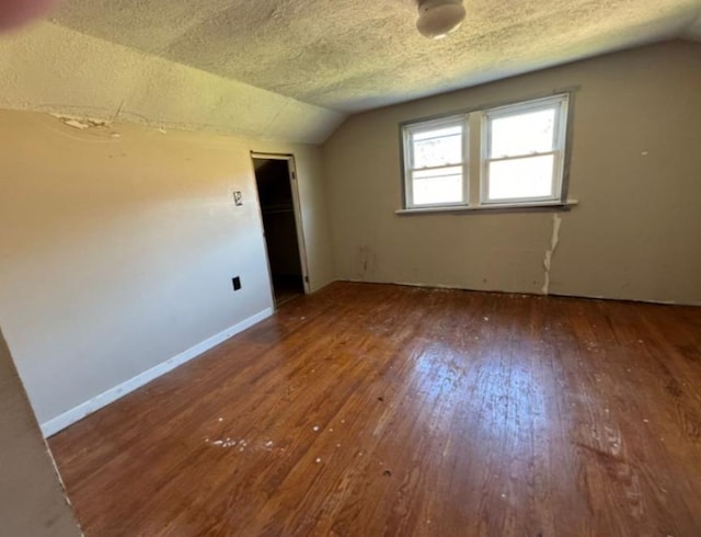 bonus room featuring hardwood / wood-style floors, vaulted ceiling, and a textured ceiling