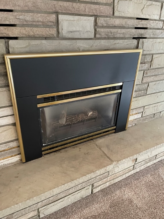 interior details featuring a fireplace with raised hearth and unfinished concrete flooring