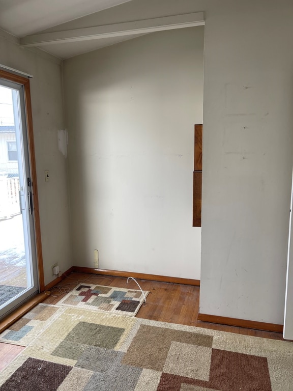 unfurnished room with hardwood / wood-style flooring and beam ceiling