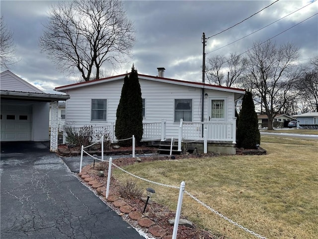 view of front of home featuring aphalt driveway and a front yard