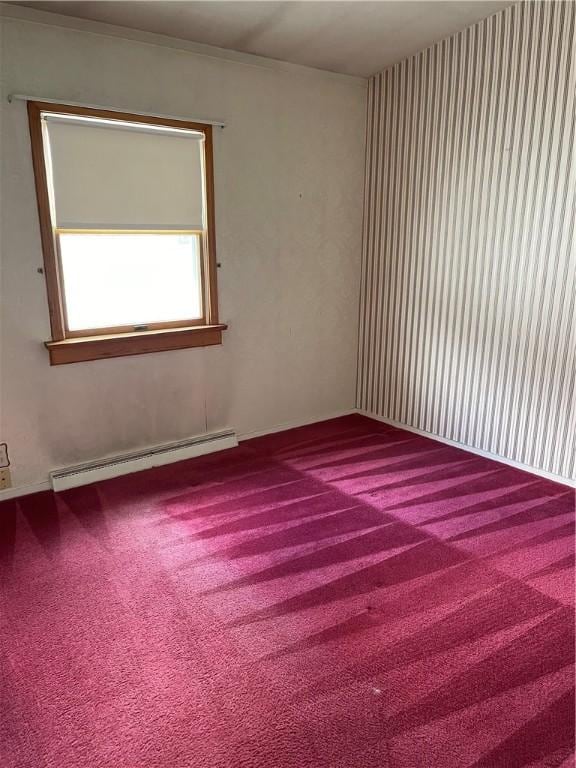 carpeted spare room featuring baseboard heating