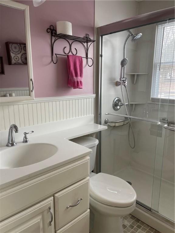 bathroom with toilet, a shower stall, and vanity