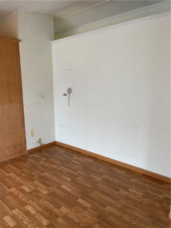 empty room featuring baseboards and wood finished floors