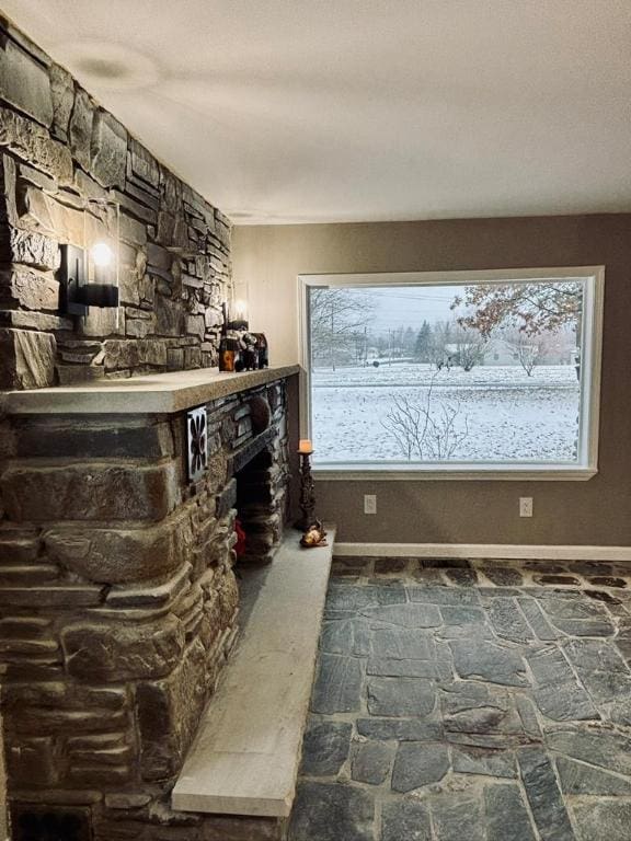 bar with a stone fireplace and a wealth of natural light