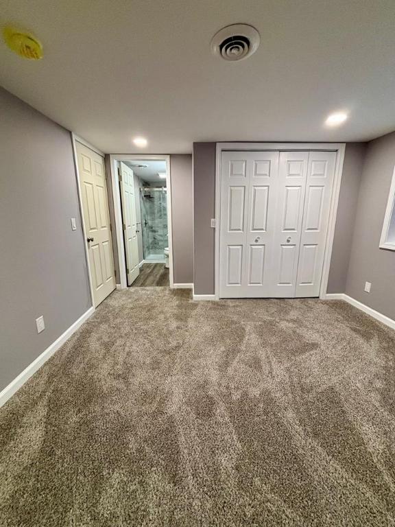 unfurnished bedroom with ensuite bathroom, carpet, and a closet