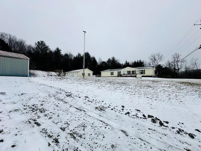 yard layered in snow with an outbuilding