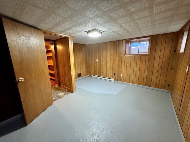 basement with baseboard heating and wood walls