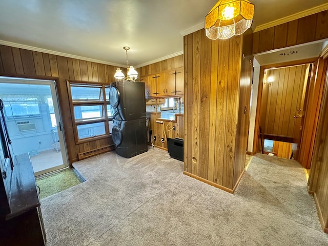 kitchen featuring hanging light fixtures, light carpet, crown molding, and wood walls