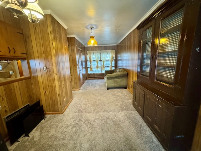 sitting room featuring crown molding, light carpet, and wooden walls