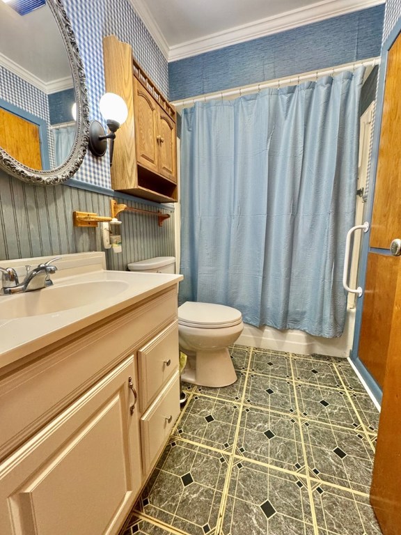 full bathroom featuring toilet, vanity, shower / tub combo with curtain, and ornamental molding