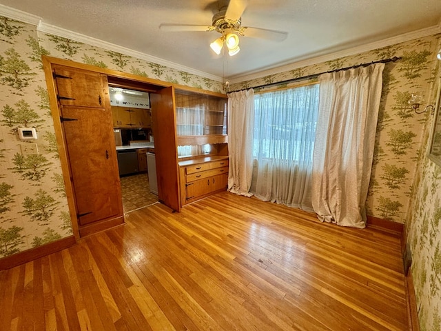 interior space with light wood-type flooring, a textured ceiling, ceiling fan, and ornamental molding