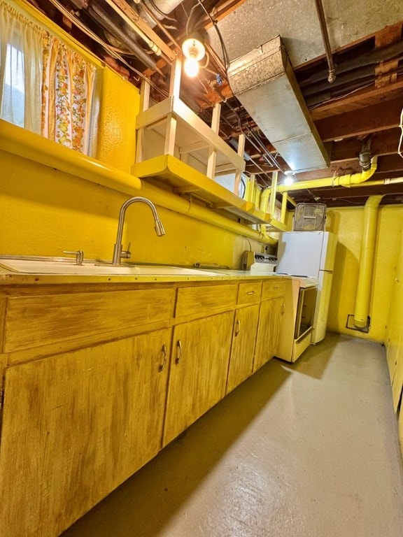 basement with sink and white fridge