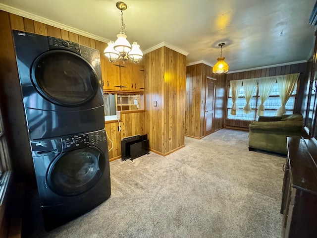 interior space featuring light colored carpet, wooden walls, ornamental molding, and stacked washer / drying machine