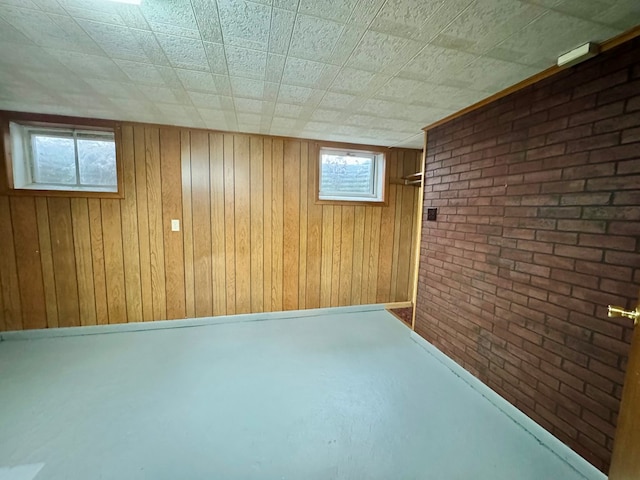 basement featuring wooden walls and brick wall