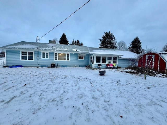 snow covered house with central air condition unit