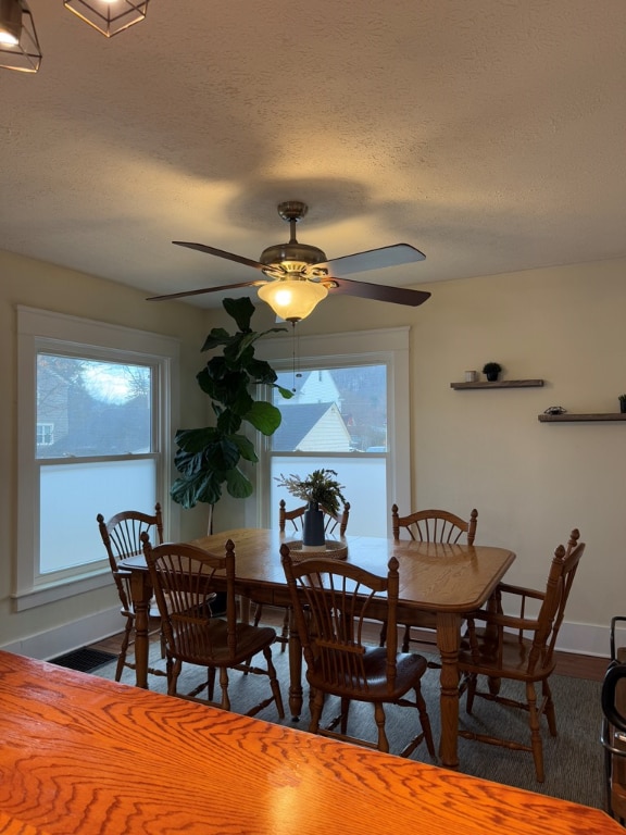 dining space with ceiling fan and a textured ceiling