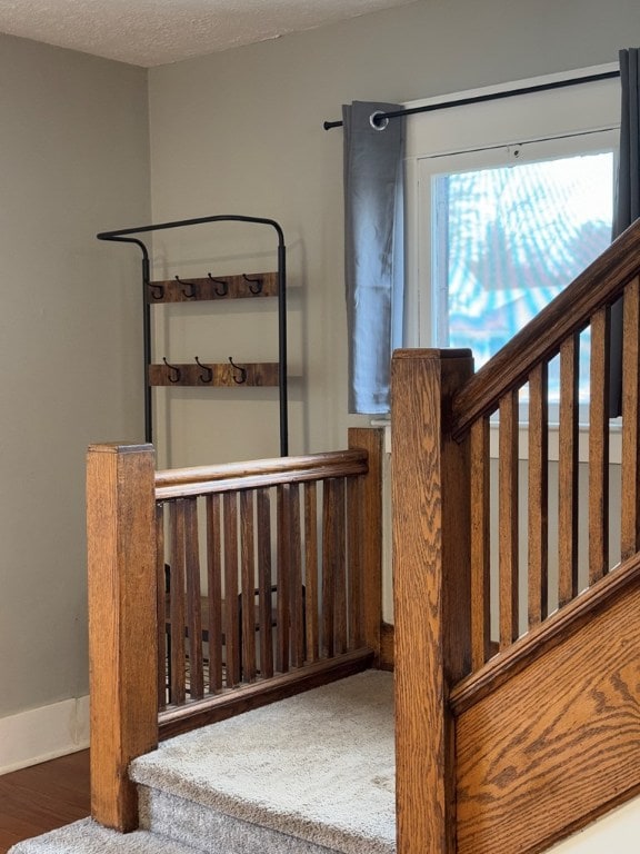 stairs featuring hardwood / wood-style floors and a textured ceiling