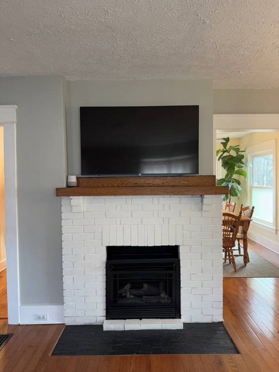 interior details featuring wood-type flooring, a fireplace, and a textured ceiling