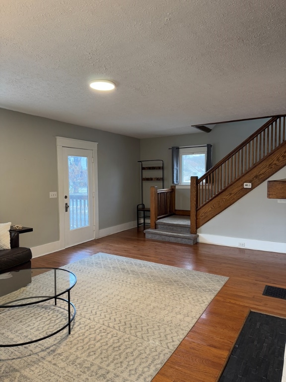 living room featuring wood-type flooring and a textured ceiling