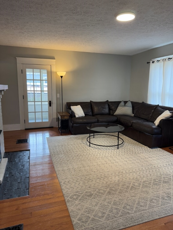 living room with wood-type flooring and a textured ceiling