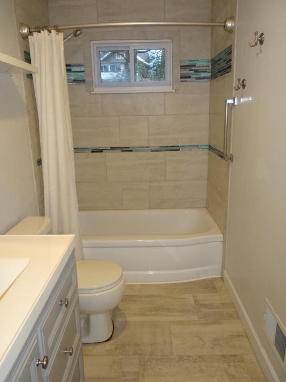 full bathroom with vanity, shower / bath combination with curtain, and toilet