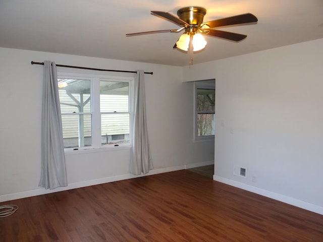 empty room featuring dark wood-type flooring and ceiling fan