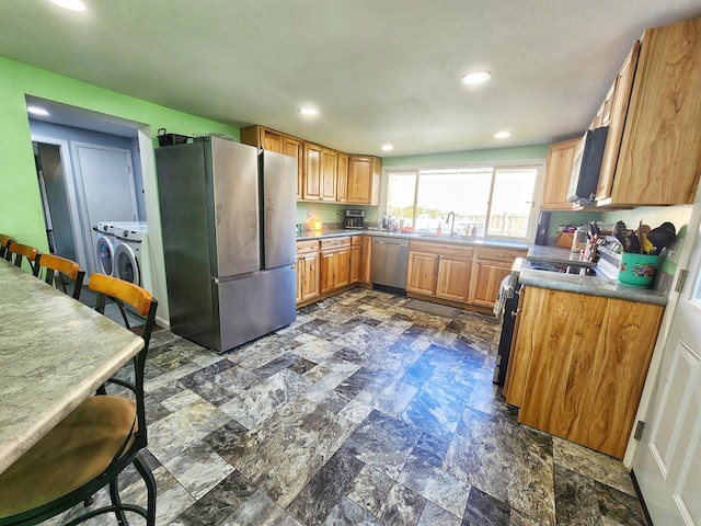 kitchen featuring sink, washer and clothes dryer, and appliances with stainless steel finishes