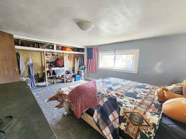 bedroom featuring a closet, a textured ceiling, and dark colored carpet