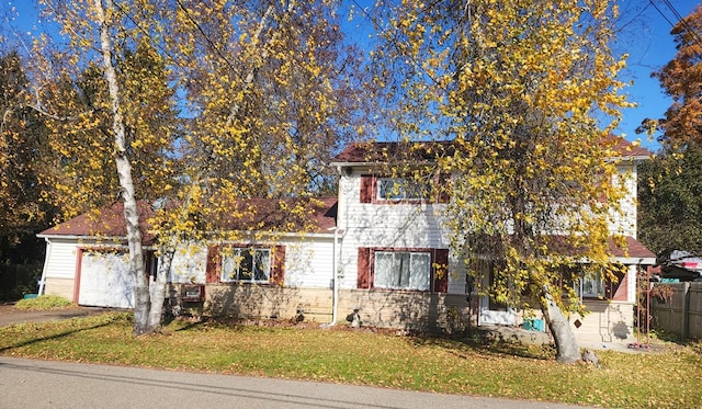 obstructed view of property featuring a garage and a front yard