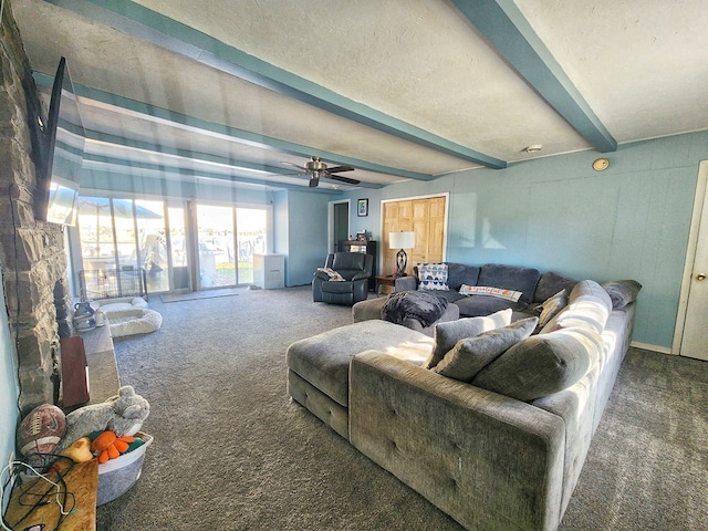 carpeted living room featuring ceiling fan and beamed ceiling