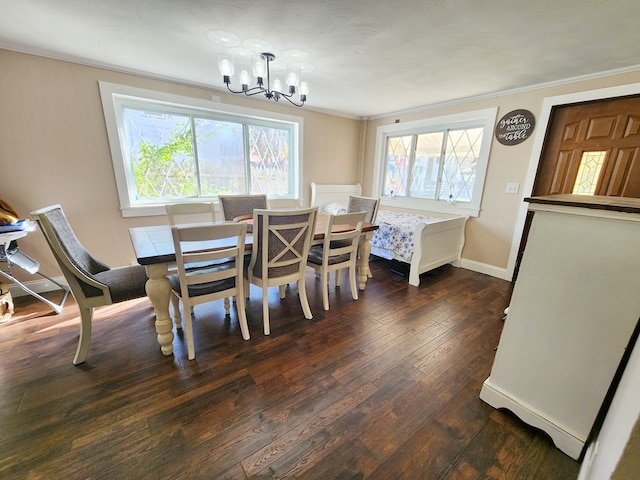 dining room with a notable chandelier, dark wood-type flooring, ornamental molding, and a healthy amount of sunlight