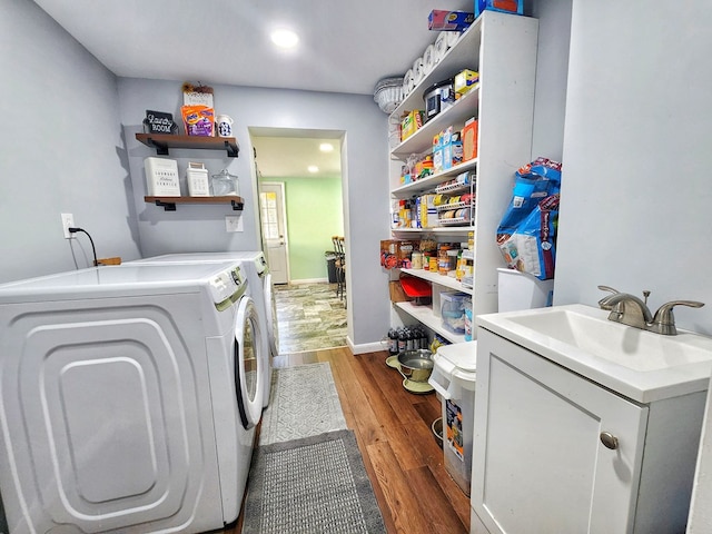 laundry area featuring washer and clothes dryer, sink, and wood-type flooring