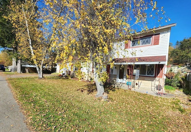 view of property hidden behind natural elements featuring a front yard