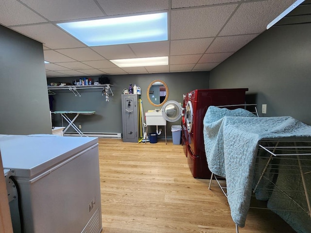 bedroom featuring wood-type flooring, fridge, a baseboard radiator, and a paneled ceiling