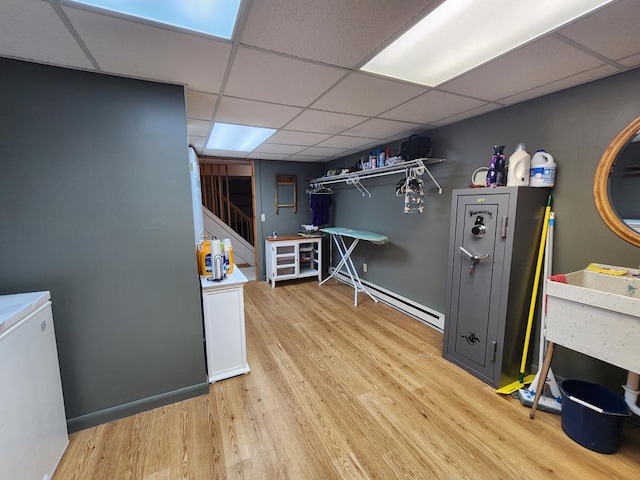 interior space with fridge, a paneled ceiling, a baseboard radiator, and light hardwood / wood-style floors