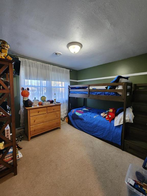 bedroom with carpet floors and a textured ceiling